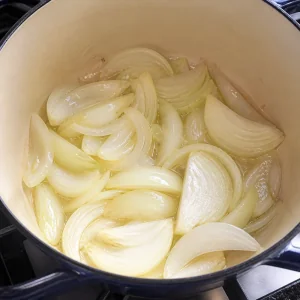 Zwiebelspalten garen in Öl, bis sie glasig sind