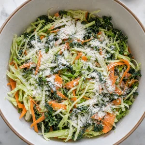 Flour sprinkled over shredded vegetables in a mixing bowl