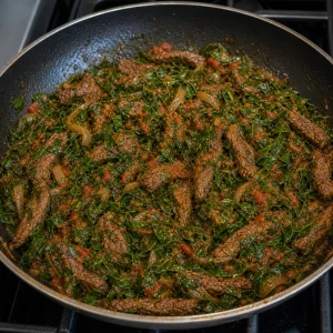 Glossy cooked collards and beef in the skillet