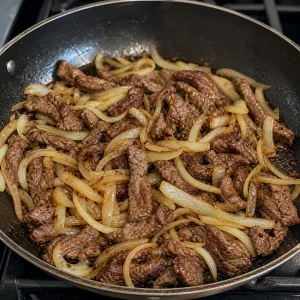 Sliced onion cooking with browned beef