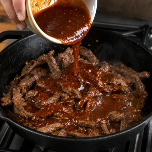 Glazura z gochujang i sosu sojowego wlewana na zrumienione paski wołowiny