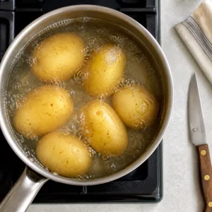 Patate che sobbollono in una casseruola d’acqua