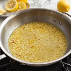 Lemon juice and white wine reducing in a skillet