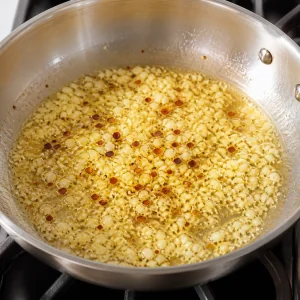 Minced garlic and red pepper flakes sizzling in butter sauce