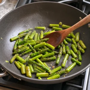 Кусочки спаржи обжариваются в оливковом масле до ярко-зеленого цвета