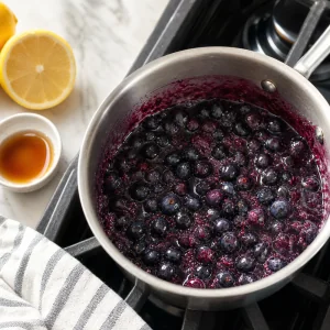 Blueberries simmering with maple syrup and lemon juice for compote