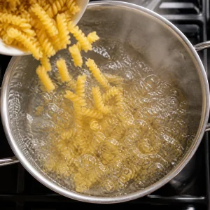 Short pasta falling into boiling salted water