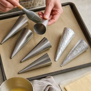 Greased metal cone forms ready on a parchment-lined tray