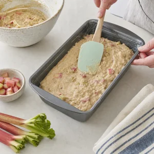 Rhubarb batter smoothed into a prepared loaf pan