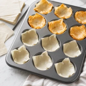 Quadrados de massa filo em formas de muffin assados até ficarem levemente dourados