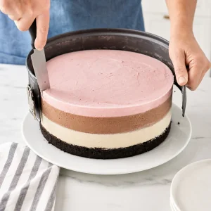 Gateau glace en couches gele decolle avec un couteau chaud pendant que le cercle du moule est ouvert