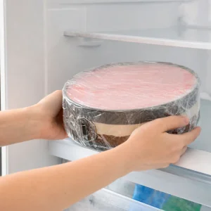 Gateau glace en couches couvert de film plastique et place au congelateur