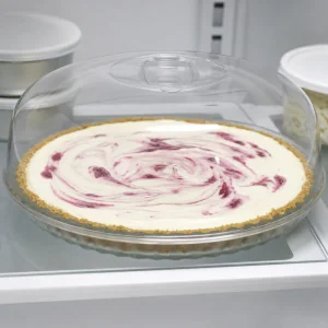 Raspberry mascarpone pie chilling under a clear cover