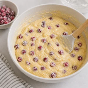 Floured cranberries folded into orange batter