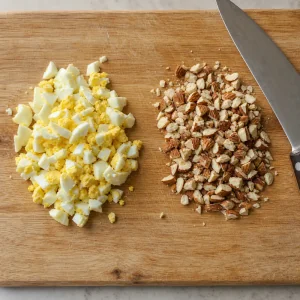 Huevos cocidos picados y almendras tostadas sobre una tabla