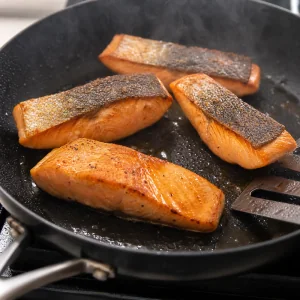 Filets de saumon retournes et saisis brievement cote chair dans la poele.