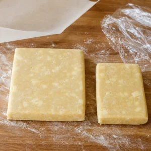 Two unequal rectangular portions of peach pie dough