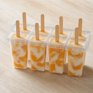 Filled peach yogurt pop molds secured with sticks and a lid
