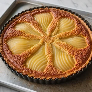Baked pear almond tart in the pan with golden filling