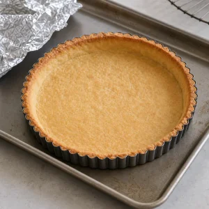 Golden blind-baked tart shell cooling in the pan