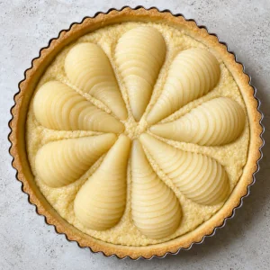 Unbaked pear tart with almond filling and fanned pear halves