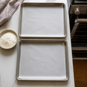 Teglie rivestite di carta da forno pronte per l’impasto dei biscotti