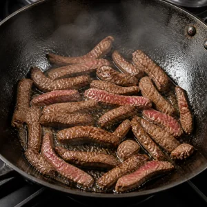 Beef strips searing in a hot wok