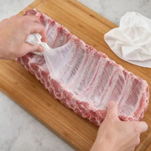 Silver skin membrane pulled from the back of raw pork ribs