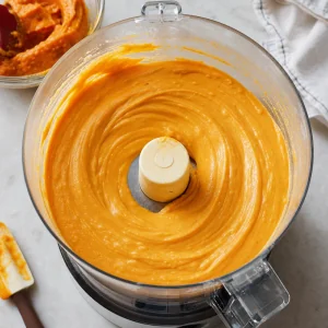 Glänzende orange Kürbis-Cheesecake-Masse im Food Processor