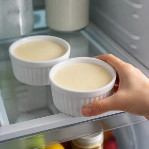 Chilled individual cheesecakes fully set in white ramekins