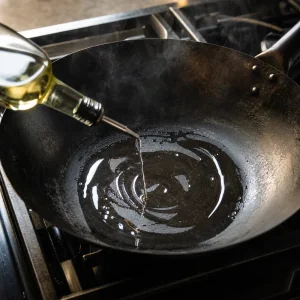 Olio fatto roteare in un wok caldo prima della cottura
