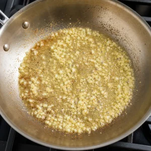 Ajo picado salteandose en mantequilla derretida