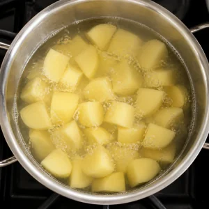 Trozos de papa hirviendo suavemente en una olla con agua