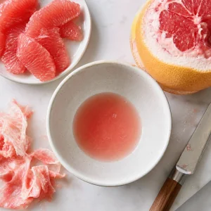 Grapefruit segments and fresh grapefruit juice collected in a small bowl