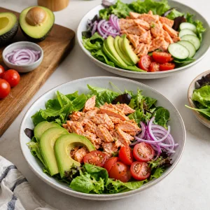 Mixed greens topped with flaked salmon avocado tomatoes cucumber and red onion