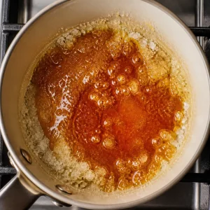 Açúcar derretendo em caramelo âmbar na panela