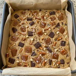 Massa de blondie crua com caramelo e sal em flocos por cima
