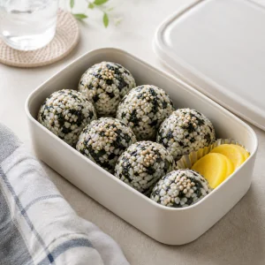 Finished jumeokbap packed in a lunch container with pickled radish.