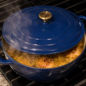 Covered Dutch oven simmering the chicken and onion sauce
