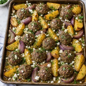 Roasted meatballs and potatoes topped with feta and herbs