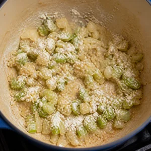Flour-coated onion and celery with garlic in the chowder pot