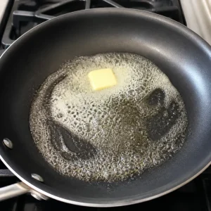 Butter schäumt in einer beschichteten Pfanne