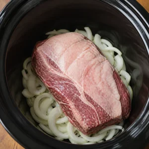 Corned beef brisket placed fat side up on the onions.