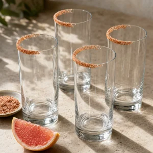 Four empty highball glasses with partial chile-salt rims