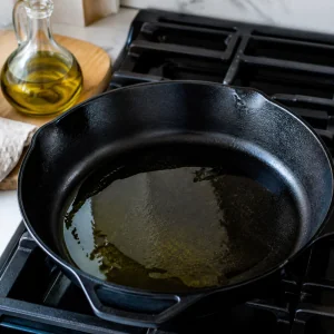 Olio d oliva che si scalda in una padella di ghisa