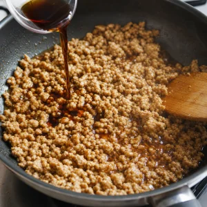 Seasoned ground chicken simmering until glossy and coated with soy mirin sauce