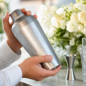 Bereifter Cocktailshaker wird geschuettelt, bis die Holunder-Gin-Mischung gut gekuehlt ist
