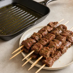Маринованные говяжьи шашлычки рядом со сковородой-гриль