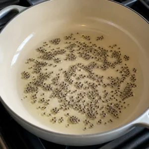 Black mustard seeds sizzling in coconut oil