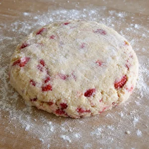 Strawberry biscuit dough patted into a thick round